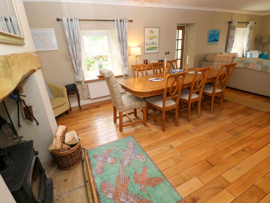 A dining room with a table and chairs at North Studdock Cottage Angle near Pembroke