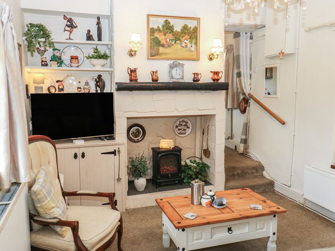 A living room with a television and a fireplace at Prospect Cottage in Ripponden