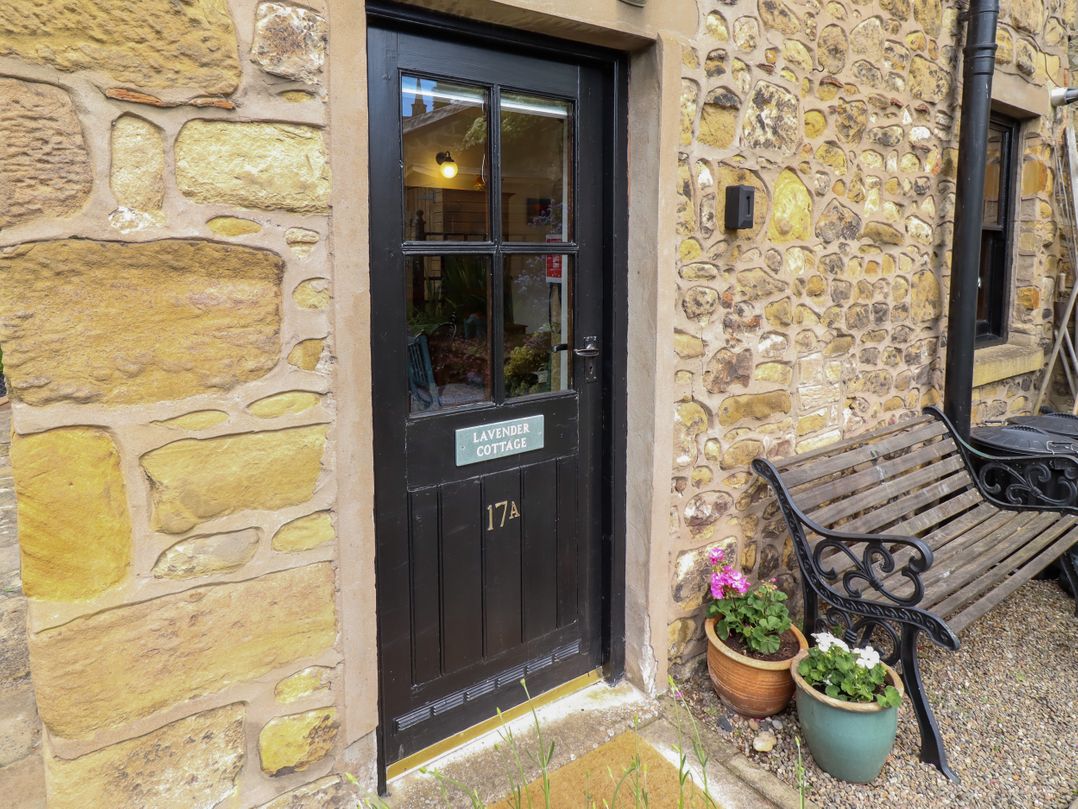 An entrance door with a nameplate and a bench at Lavender Cottage in Alnwick
