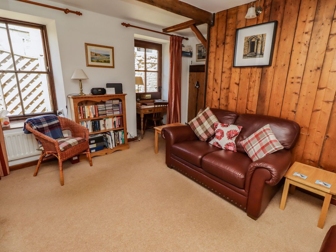 A living room with a sofa and bookshelf at Lavender Cottage (Bailiffgate) in Alnwick