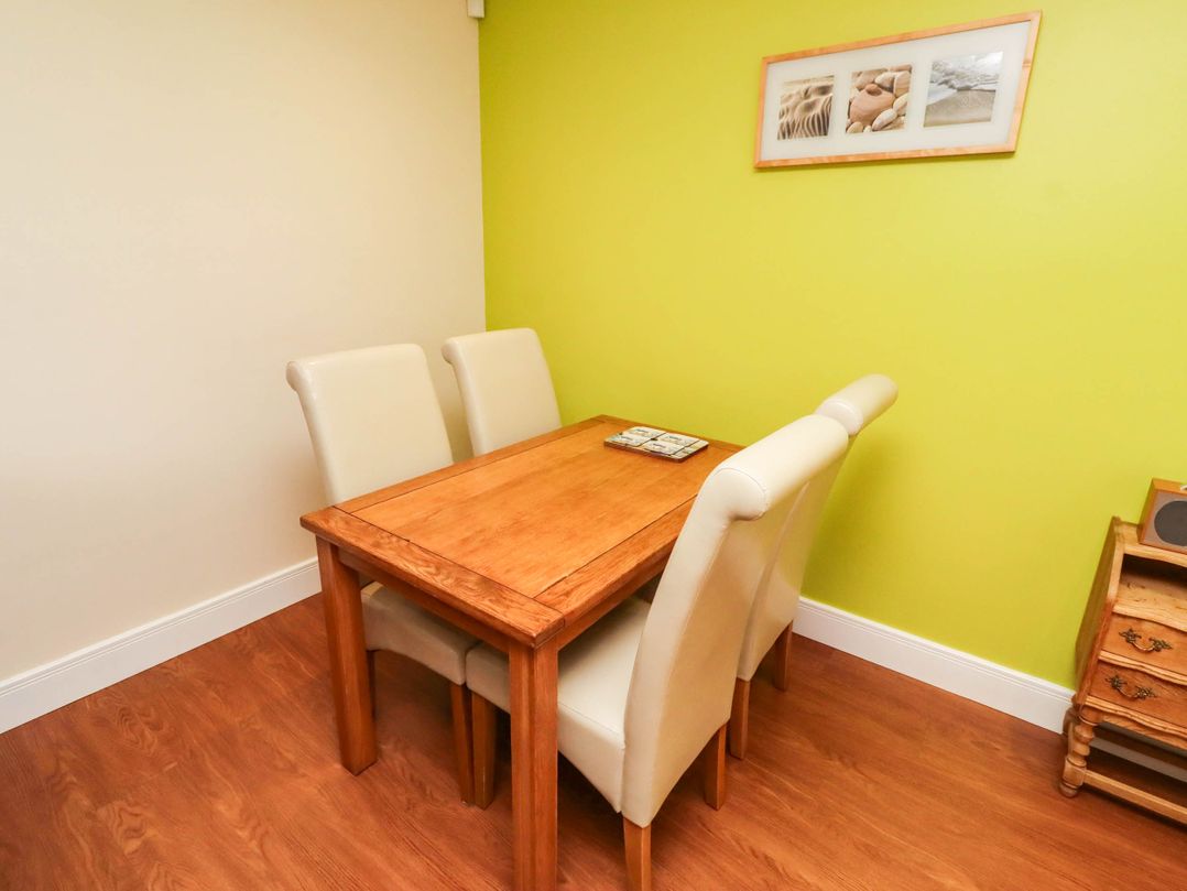 A dining room with a table and chairs at Flora Cottage Beadnell