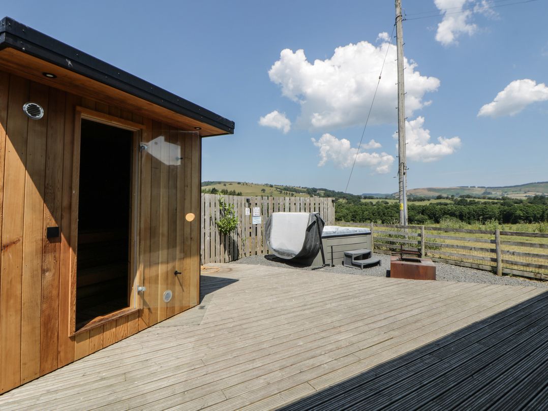 An outdoor space with a sauna and hot tub at Tin Shed Nantmel near Rhayader