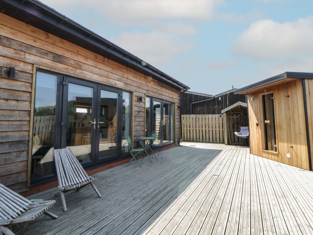 An outdoor area with wooden decking and furniture at Tin Shed Nantmel near Rhayader