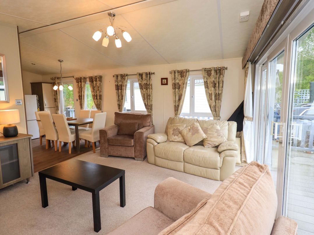 A living room with a sofa and dining area at 41, Grandma's Cottage South Lakeland Leisure Village near Carnforth