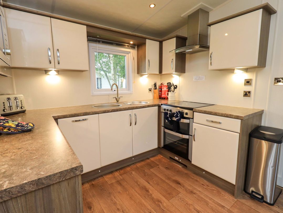 A kitchen with a sink and cooking stove at 41, Grandma's Cottage South Lakeland Leisure Village near Carnforth