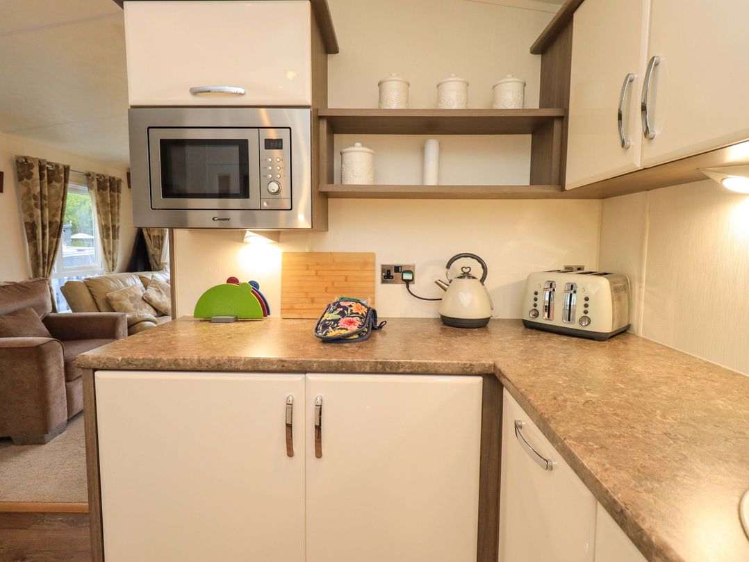A kitchen with a microwave, kettle, and toaster at 41, Grandma's Cottage South Lakeland Leisure Village near Carnforth