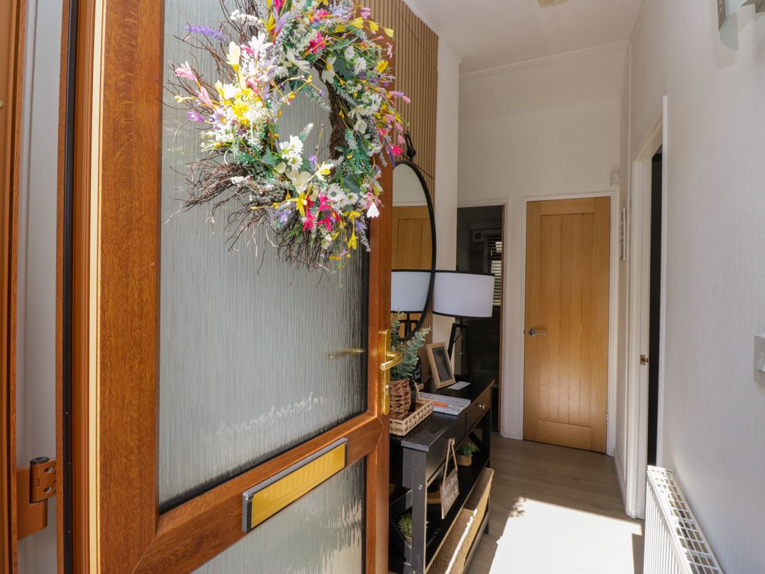 A hallway with a console table and lamp at Ruskin Lodge, Langdale 16, White Cross Bay near Windermere