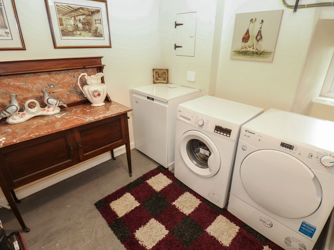 A laundry room with a washer, dryer and sideboard at The LA'AL Cragg in Kirkby Stephen