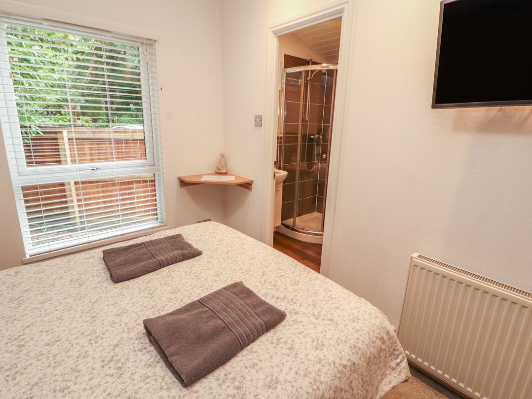 A bedroom with a bed and towels at Willows Lodge near White Cross Bay, near Windermere