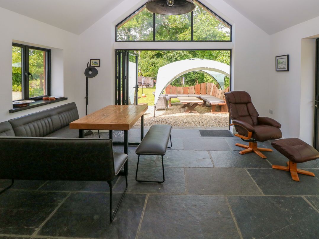A dining room with a table and sofa at Glas y Dorlan Nevern near Newport, Pembrokeshire