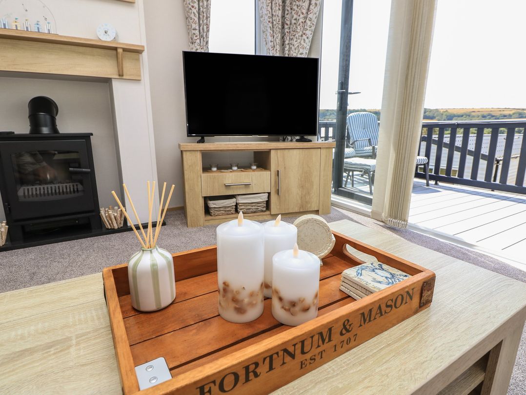 A living room with candles and a television at 31 Crosswinds Bembridge