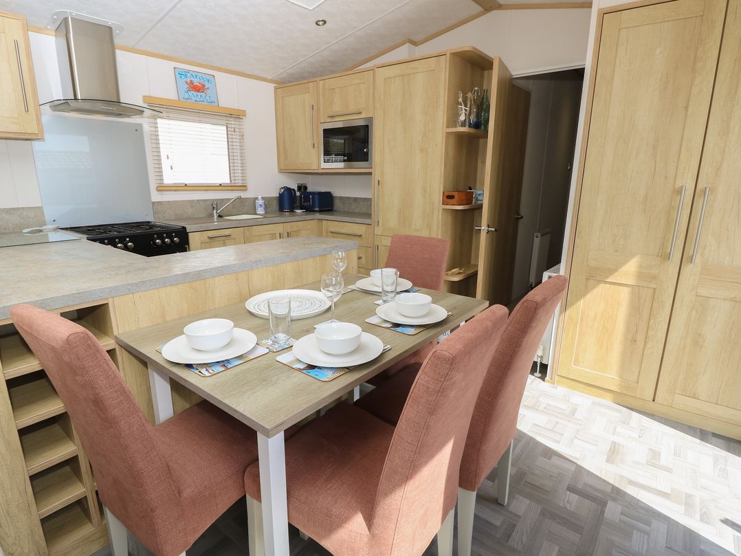 A kitchen with a table and chairs at 31 Crosswinds in Bembridge