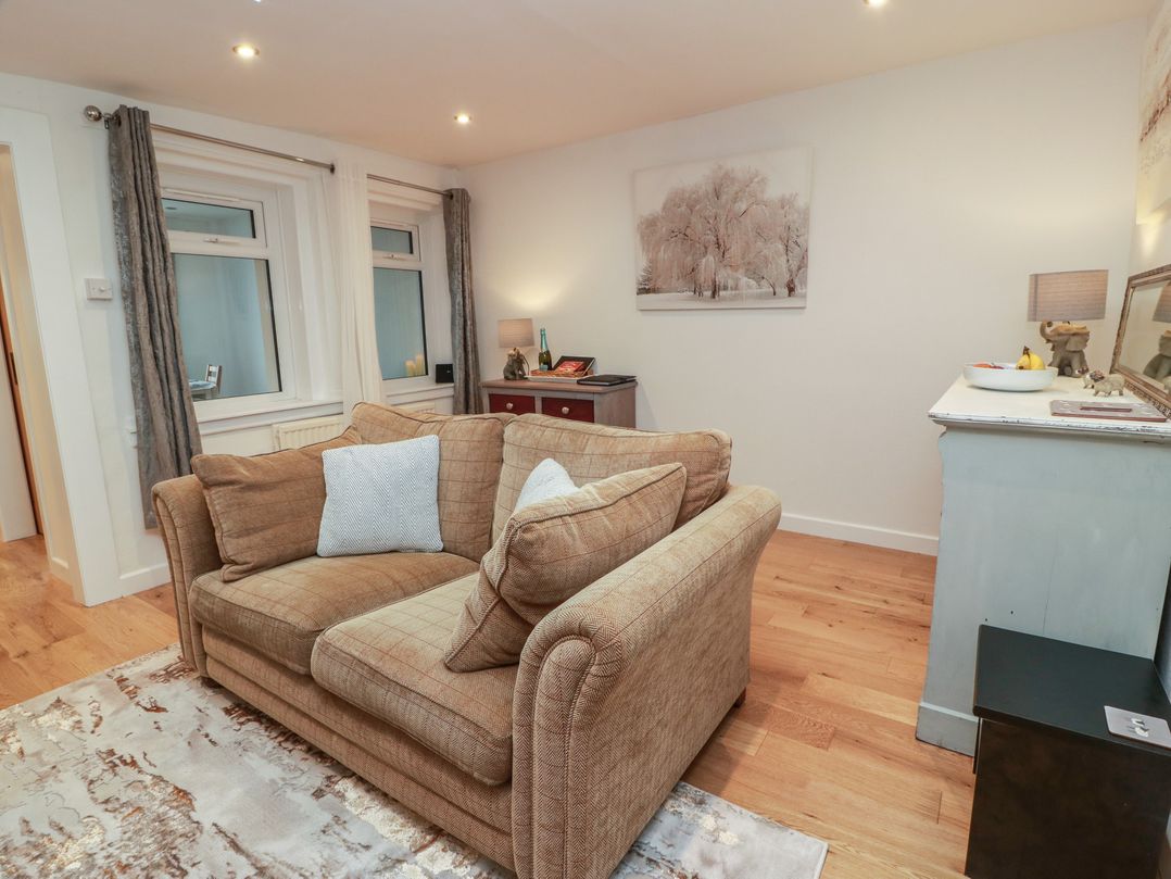 A living room with a sofa and table at Rosalin Cottage in Dreghorn near Irvine