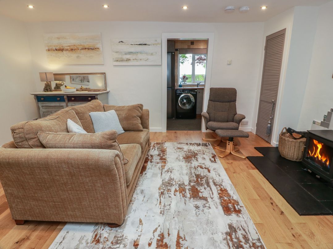 A living room with a sofa and fireplace at Rosalin Cottage in Dreghorn near Irvine