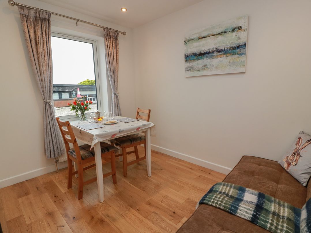 A dining room with a table and chairs at Rosalin Cottage in Dreghorn near Irvine