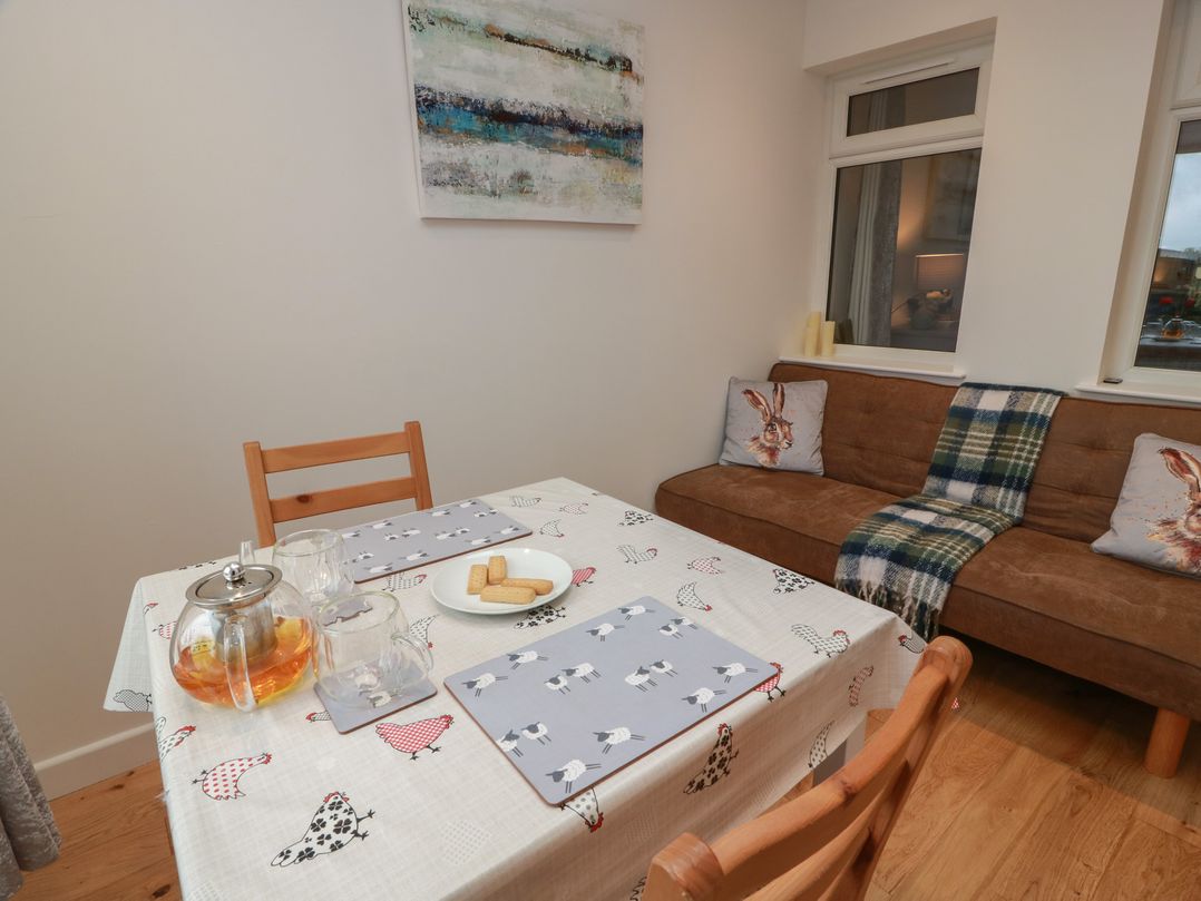 A dining room with a table set for tea at Rosalin Cottage in Dreghorn near Irvine