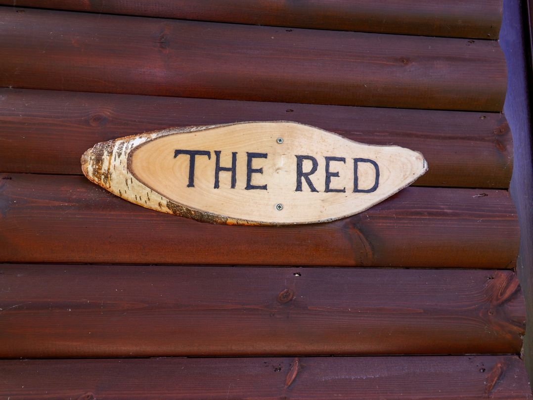 A wooden plaque with the text The Red at The Red in Llanerch Park near St Asaph