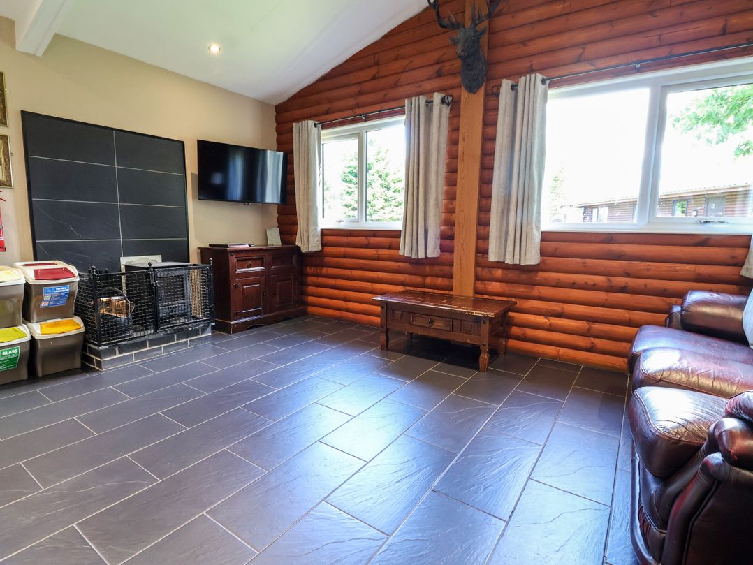 A living room with a television and fireplace at The Red in Llanerch Park near St Asaph