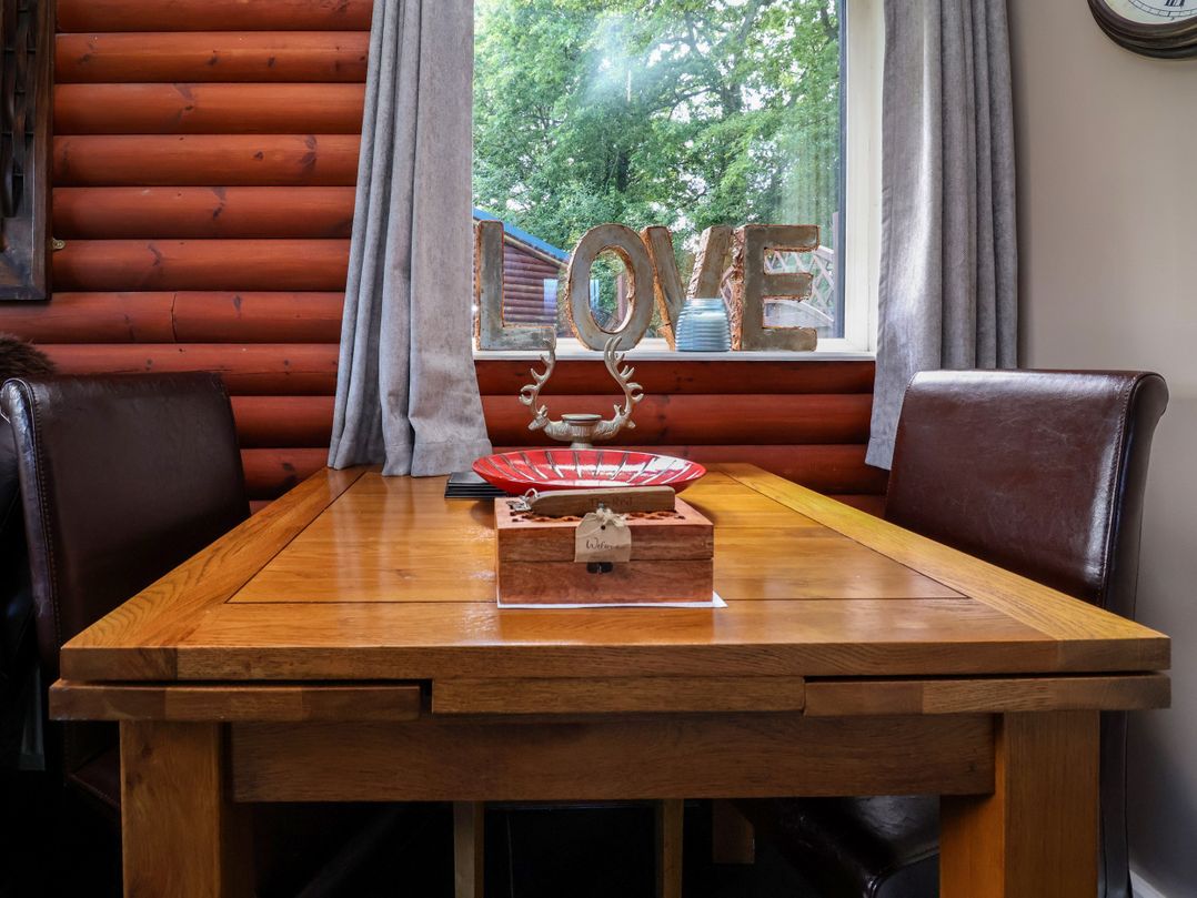 A dining room with a wooden table and love sign at The Red in Llanerch Park near St Asaph