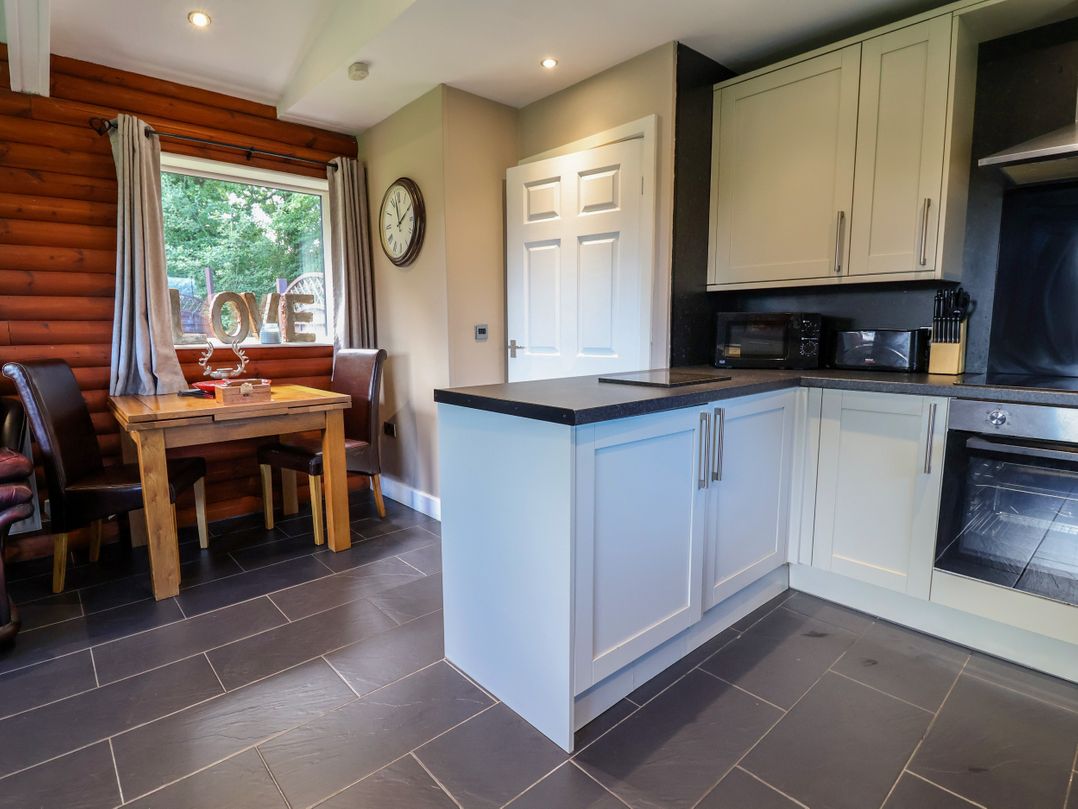 A kitchen with wooden table and chairs at The Red in Llanerch Park near St Asaph