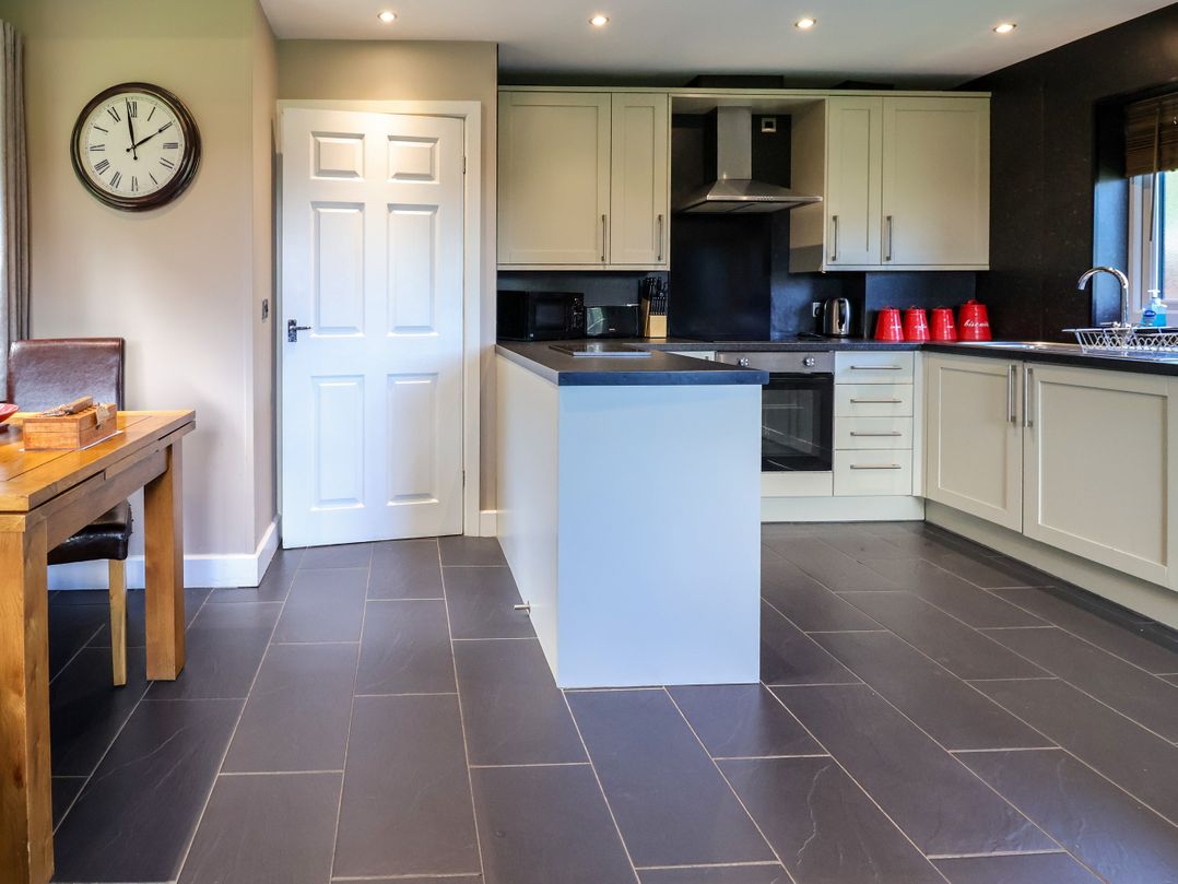 A kitchen with a table and chairs at The Red in Llanerch Park near St Asaph
