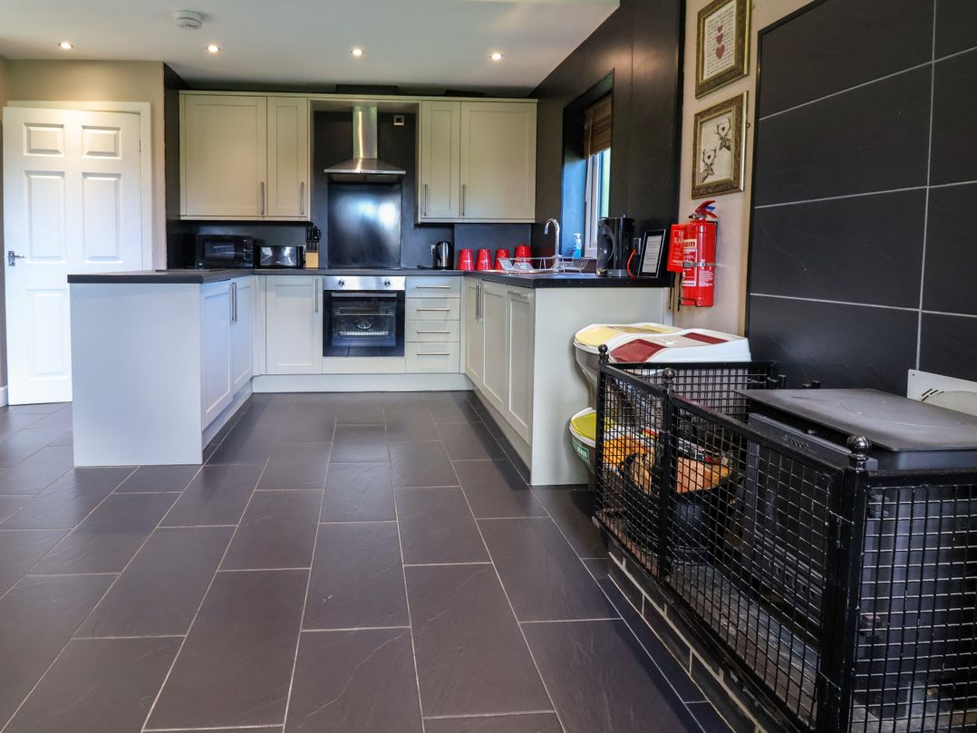 A kitchen with appliances and a dog crate at The Red in Llanerch Park near St Asaph