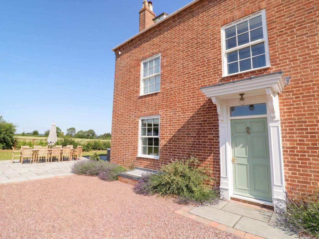 An outdoor area with a dining table and chairs at Daniels Farmhouse in Claines