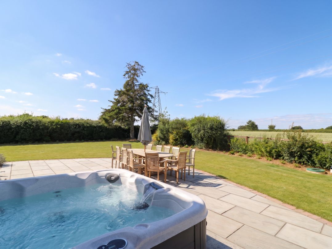 A garden with a hot tub and dining table at Daniels Farmhouse in Claines
