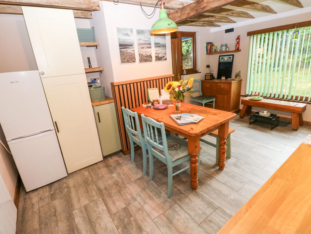 A kitchen with a dining table and chairs at 2 Strand Cottages in Laugharne