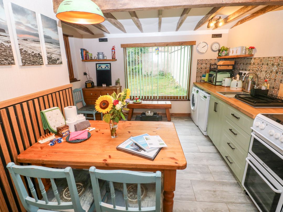 A kitchen with a table and chairs at 2 Strand Cottages, Laugharne