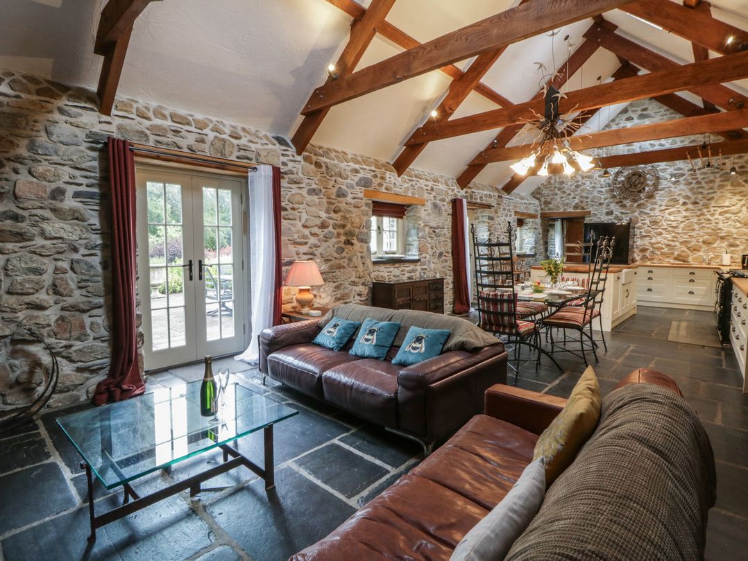 A living room with a sofa and dining table at St Dogwells Barn near Wolfscastle