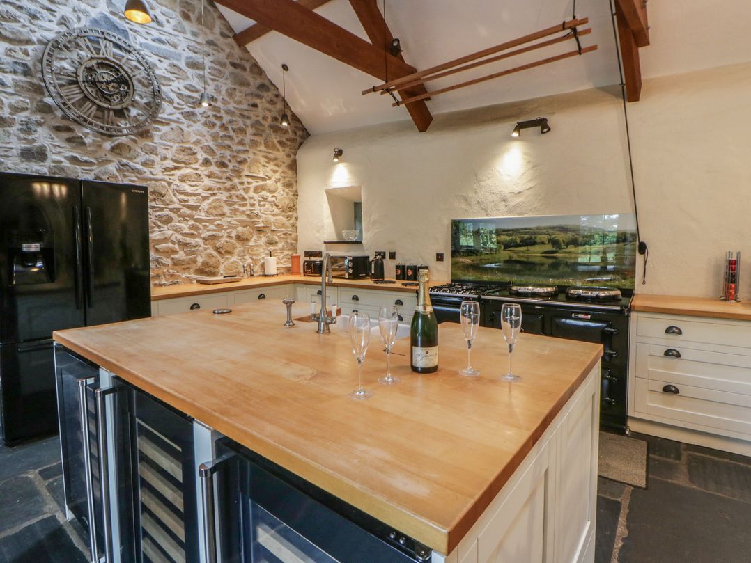 A kitchen with a refrigerator and kitchen island at St Dogwells Barn near Wolfscastle