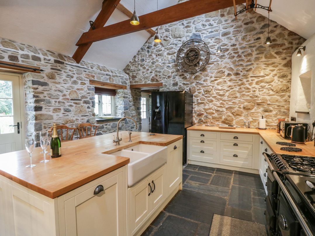 A kitchen with a sink, stove, and refrigerator at St Dogwells Barn near Wolfscastle