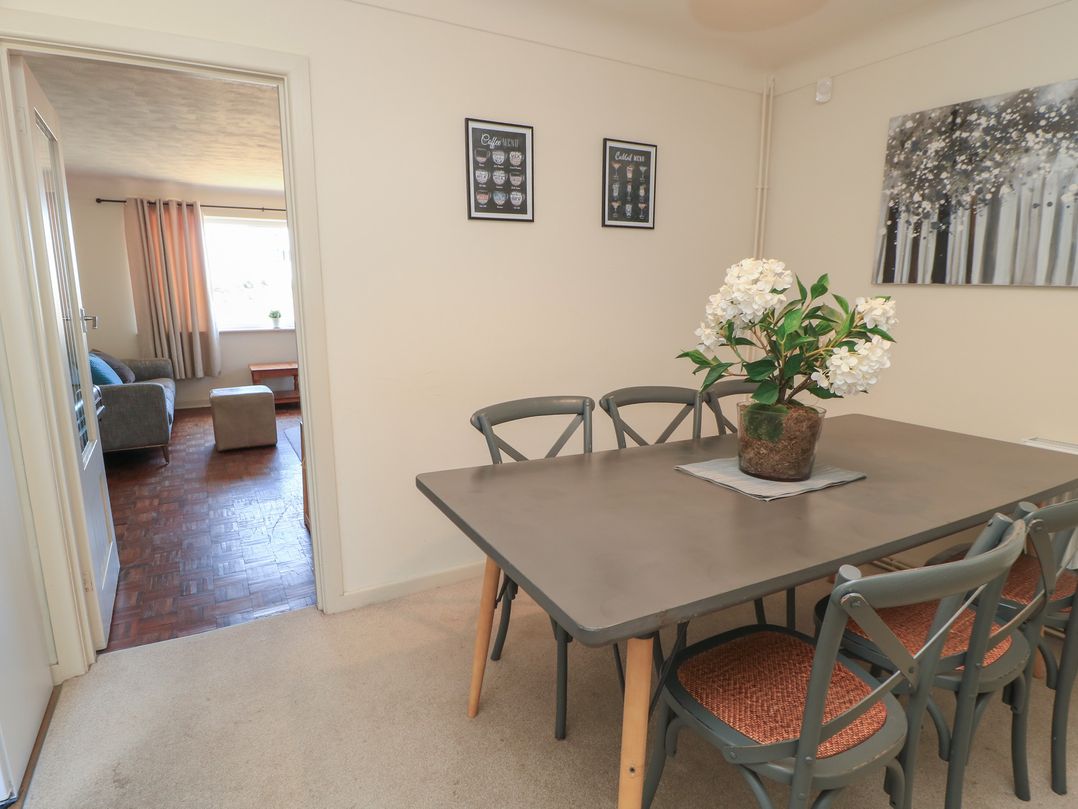 A dining area with a table and chairs at Bayview Cottage Southbourne