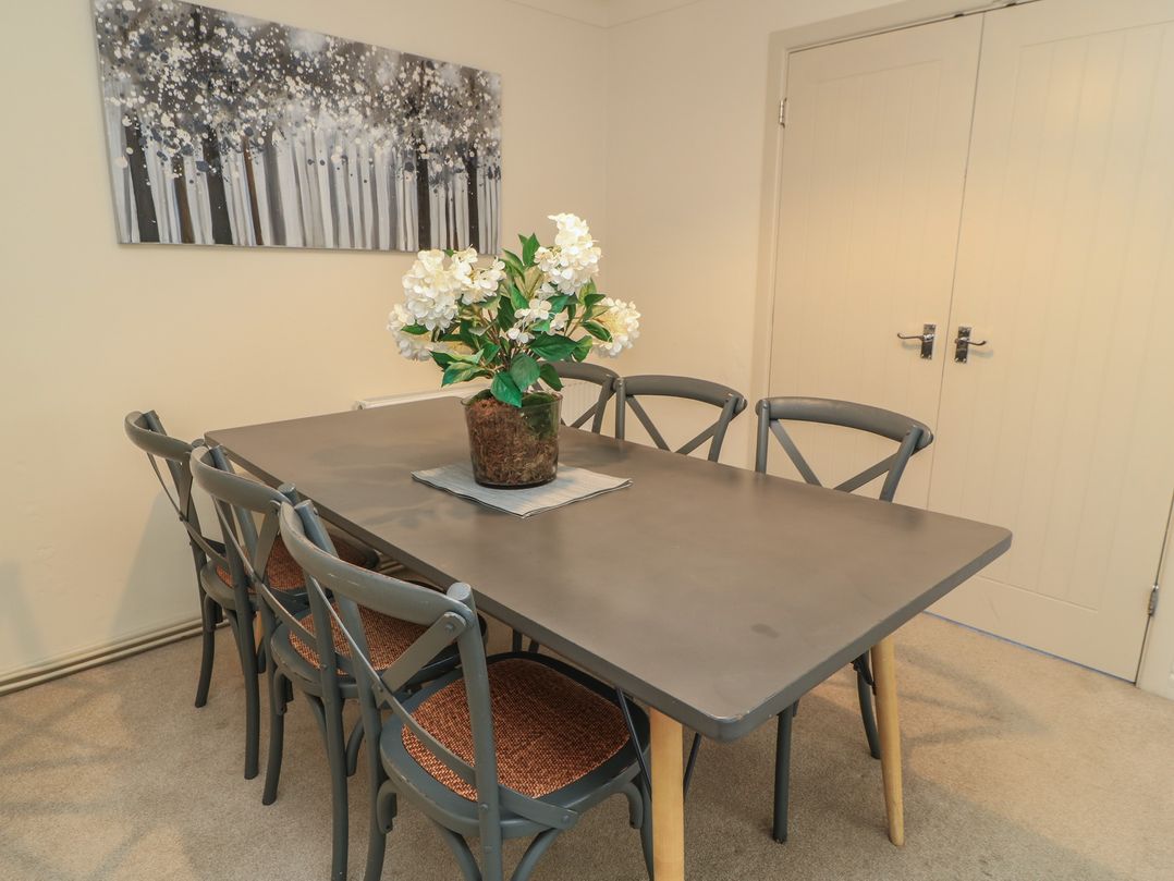 A dining room with a table and chairs at Bayview Cottage Southbourne