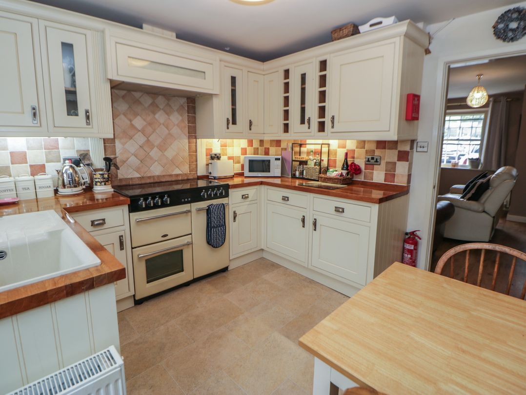 A kitchen with cabinets and appliances at Rose Cottage in Hartington