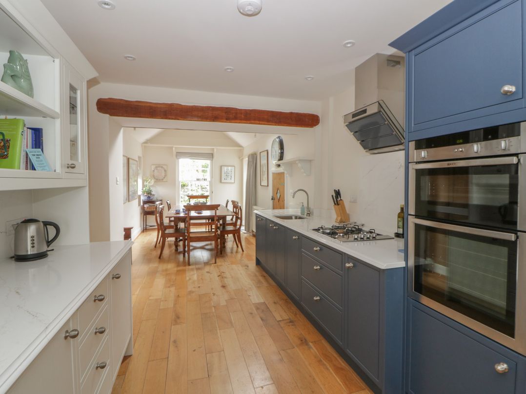 A kitchen with cabinets and a dining area at Ty Clyd in Newport, Pembrokeshire