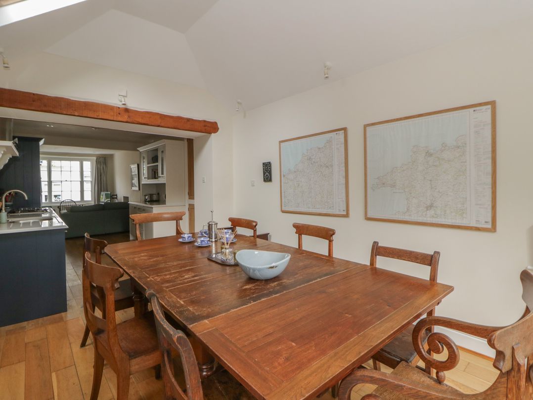 A dining room with a wooden table and maps on the wall at Ty Clyd Newport, Pembrokeshire