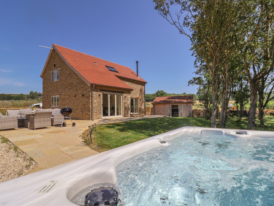 An outdoor area with furniture and a hot tub at The Fox Den in East Coker