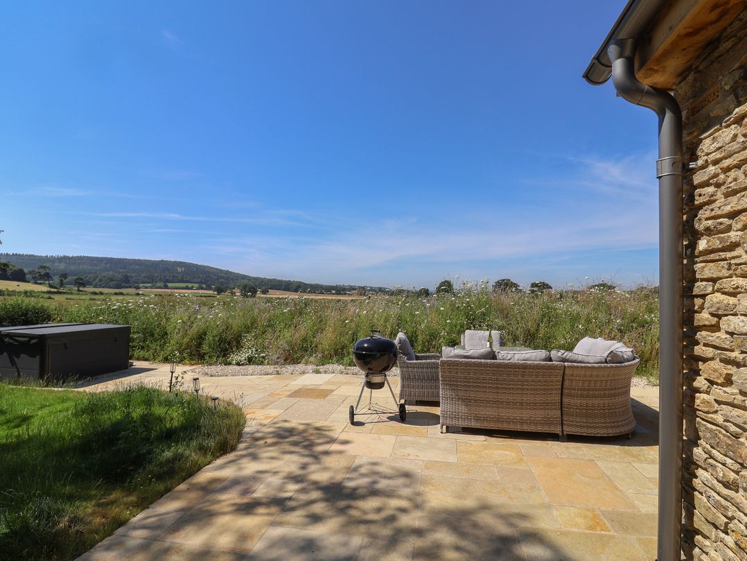 An outdoor area with a sofa and barbecue grill at The Fox Den in East Coker