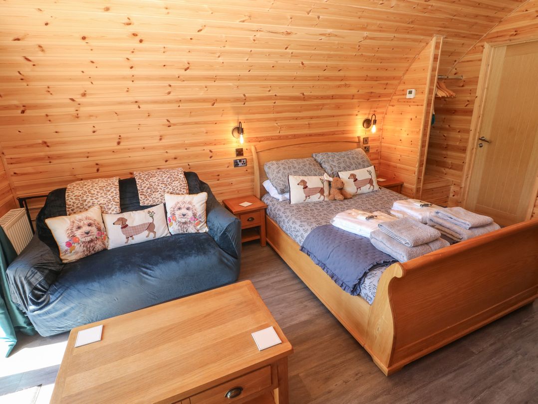 A bedroom with a bed and sofa at Lodge 2 near Pontyates