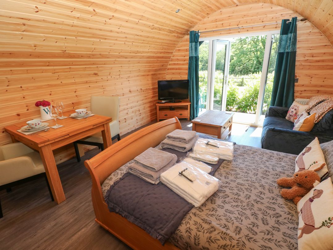 A bedroom with a bed and dining table at Lodge 2 near Pontyates