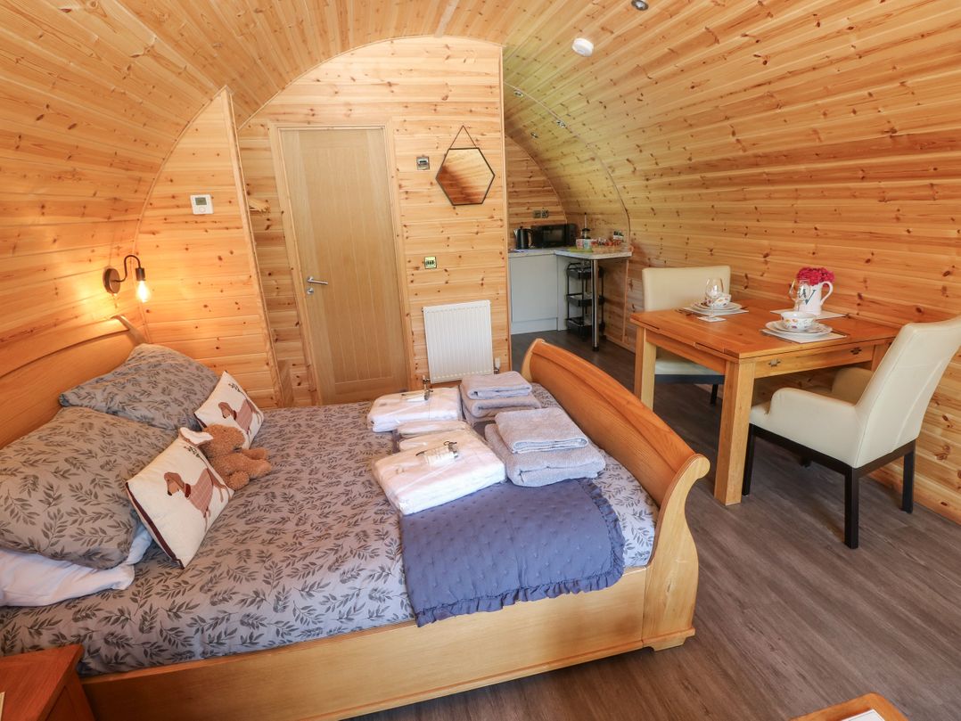 A studio room with a bed and dining table at Lodge 2 near Pontyates