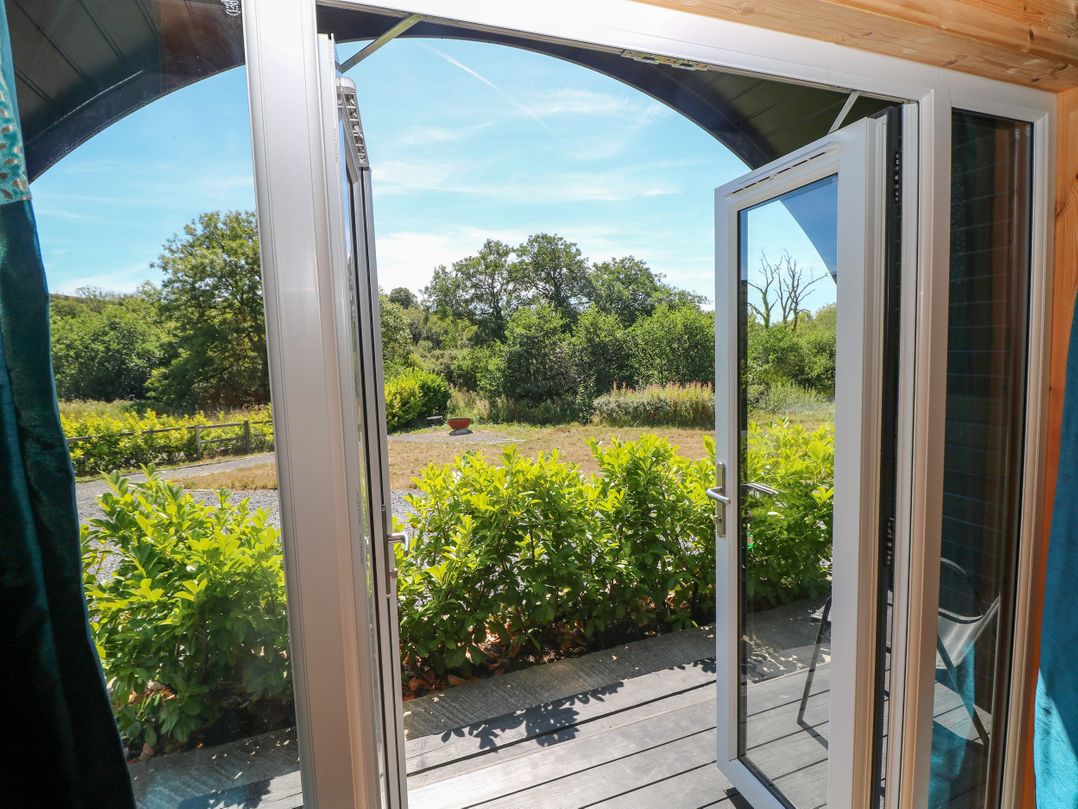 An outdoor area with double doors leading to a garden at Lodge 2 near Pontyates