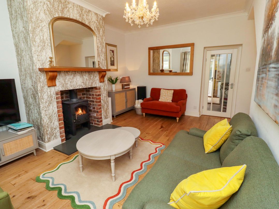A living room with a fireplace and seating area at Rose Briar Cottage in Morpeth