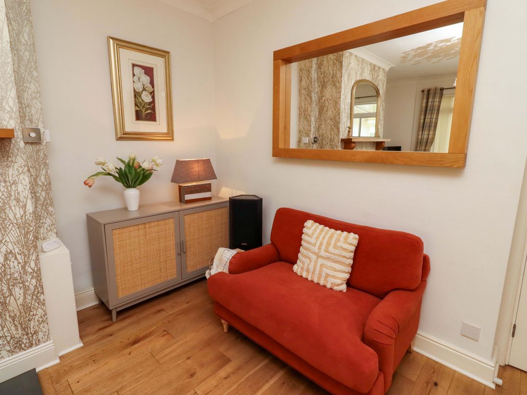 A living room with a sofa and a lamp at Rose Briar Cottage in Morpeth