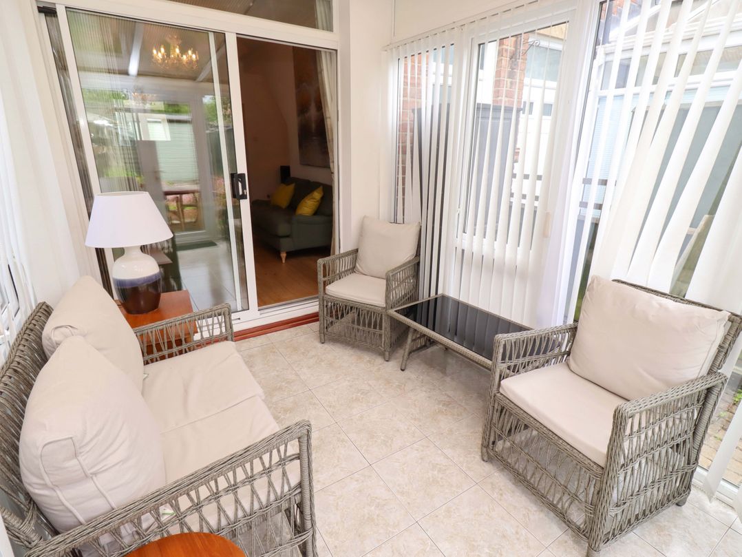 A conservatory with seating and a coffee table at Rose Briar Cottage in Morpeth
