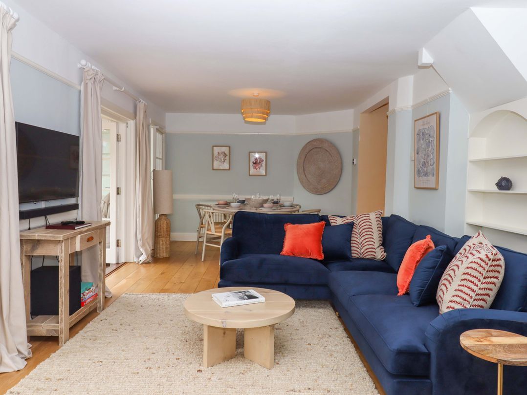 A living room with a sofa and television at The Porthole in Newton Ferrers