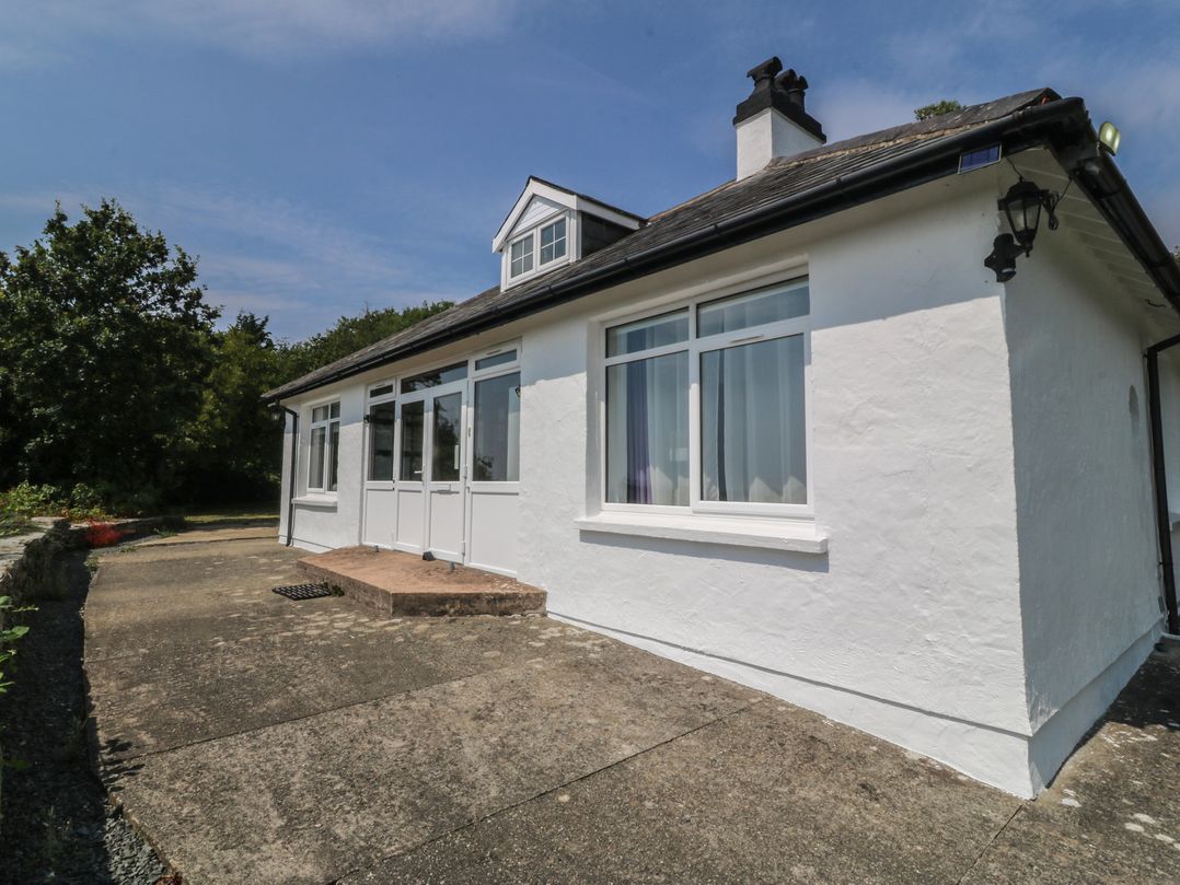 An exterior view of a house with windows and a patio at Seaview Hafod Y Graig Morfa Bychan
