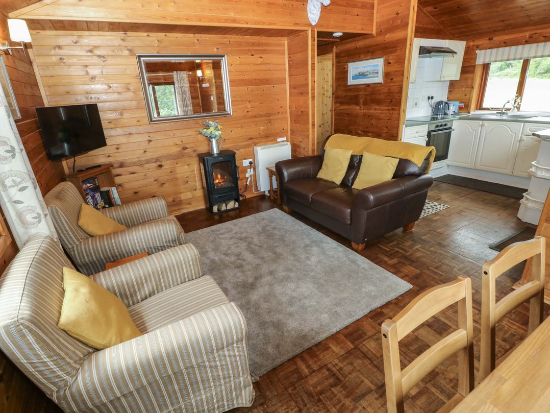 A living room with a sofa and armchairs at Ash Lodge in Mynydd Cerrig near Porthyrhyd